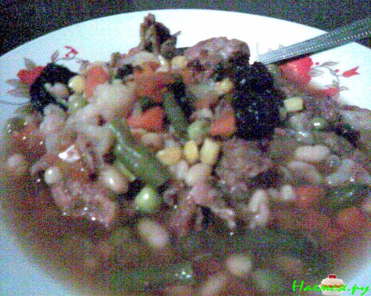 Говяжий суп с фасолью, овощами и черносливом в керамической посуде