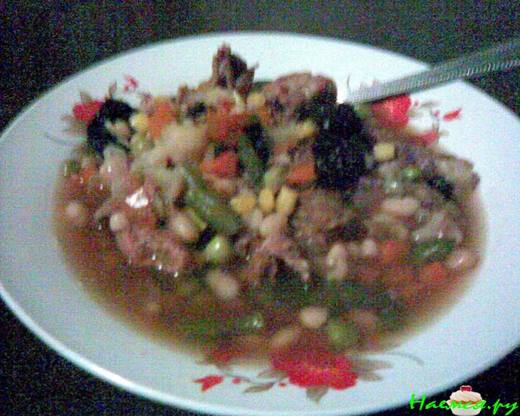 Говяжий суп с фасолью, овощами и черносливом в керамической посуде