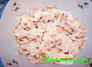 В салатную миску выложить слой, состоящий из куриного мяса, и обильно смазать его майонезом