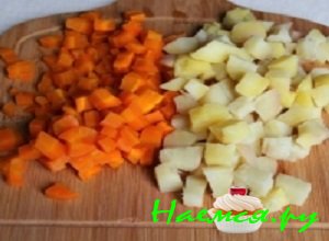 Картофельные клубни и морковку отварить до готовности в подсоленной воде, снять с овощей кожуру и порезать их небольшими по размеру кубиками