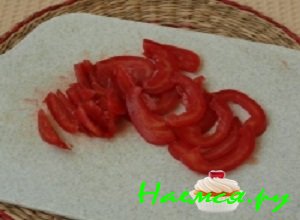 Помидор промыть под проточной водой, разрезать пополам и вынуть мякоть с семенами