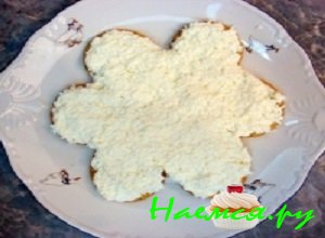 На плоскую тарелочку аккуратно выложить слой круглых соленых крекеров