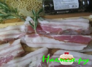 Накрыть полоски приправленной розмарином и специями рыбки слайсами бекона.