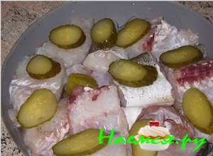 Потом возьмите соленые огурчики и порежьте их в виде кружочков. Поерзанные огурцы положите сверху на рыбу.