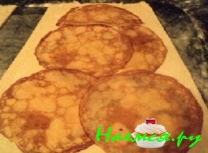 На пласт дрожжевого теста аккуратно выложить основу из приготовленных блинчиков