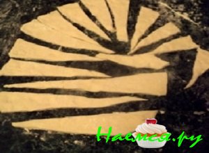 Оставшуюся часть дрожжевого теста раскатать пластом толщиной не более 4 мм и вырезать из него удлиненные треугольники.