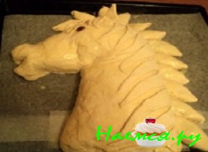 Из них выложить прядки гривы. Сформировать глаз и ушки лошади. Поставить противень с пирогом в теплое место, чтобы тесто немного поднялось.