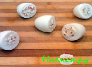 Нафаршировать яйца приготовленной и выложить их на плоскую тарелочку, предварительно украшенную веточками зелени