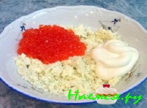 Из остальных половинок яиц аккуратно вынуть желтки, которые следует размять вилочкой и добавить к ним майонез и лососевую икорку