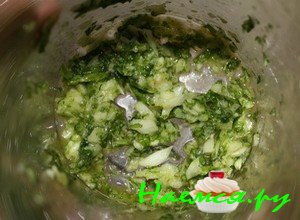 Теперь возьмите чистую емкость, положите в нее предварительно почищенный чеснок, промытый и просушенный базилик, добавьте оливкового масла в количестве одной столовой ложки и с помощью блендера измельчите ингредиенты