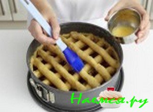 Из теста, которое у Вас осталось, сделайте решетку и красиво положите ее сверху джема. Затем возьмите емкость, отправьте в нее один яичный желток, добавьте теплую воду, ингредиенты перемешайте и яичной массой смажьте тестовые решетки.