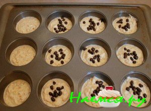 Теперь возьмите столовую ложку, набирайте ей тесто и выкладывайте в формочки, наполняйте их до серединки