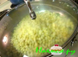 По истечении данного времени отправьте в сковородку с обжаренным луком кукурузу, перемешайте ингредиенты, накройте крышкой