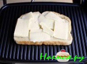 Положите сливочное масло на хлеб